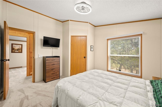 bedroom with a textured ceiling, ornamental molding, and light carpet