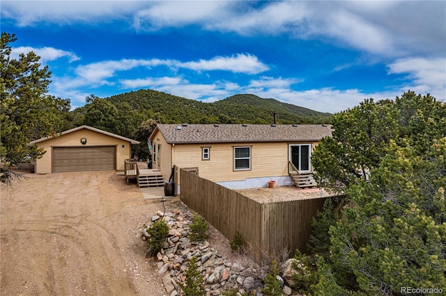 exterior space with a mountain view, an outbuilding, a garage, and entry steps