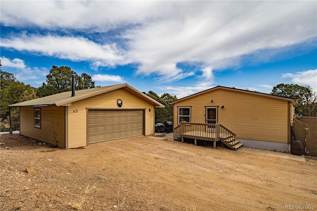 view of front of property with a garage, an outbuilding, and a wooden deck