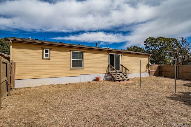 rear view of property featuring a fenced backyard and entry steps