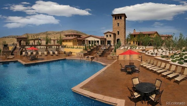 15576 W Washburn Cir, Lakewood, CO 80228 - community pool featuring a patio area, stairway, and a mountain view