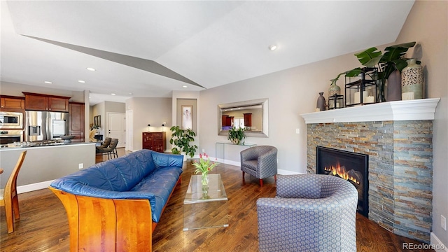 6945 N Fargo Trl, Littleton, CO 80125 - living area featuring vaulted ceiling, a stone fireplace, wood finished floors, baseboards, and recessed lighting