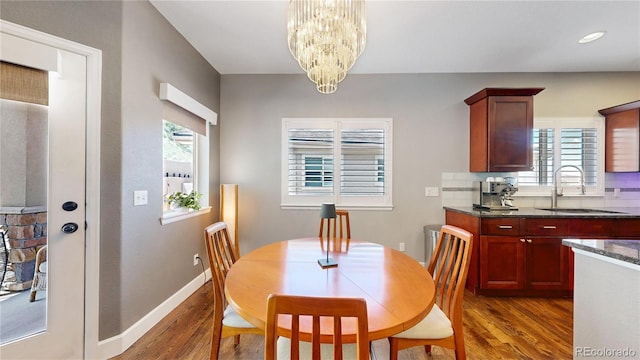 6945 N Fargo Trl, Littleton, CO 80125 - dining area with wood finished floors, a chandelier, and baseboards