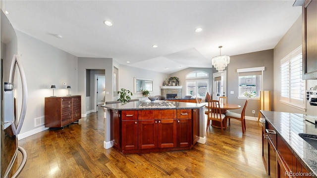 6945 N Fargo Trl, Littleton, CO 80125 - kitchen with dark brown cabinets, stainless steel fridge, a fireplace, dark wood finished floors, and baseboards