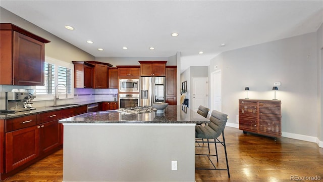 6945 N Fargo Trl, Littleton, CO 80125 - kitchen with stainless steel appliances, a sink, a kitchen island, a breakfast bar, and dark brown cabinets