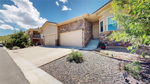 6945 N Fargo Trl, Littleton, CO 80125 - view of front of home featuring a garage, concrete driveway, and stone siding