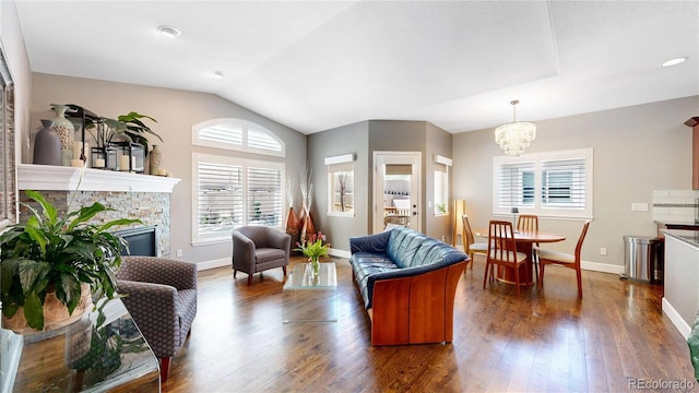 6945 N Fargo Trl, Littleton, CO 80125 - living area featuring vaulted ceiling, a chandelier, a fireplace, dark wood-style floors, and baseboards