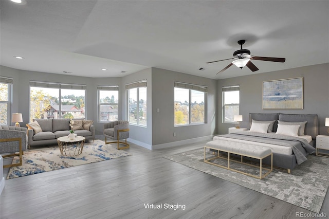 bedroom featuring light hardwood / wood-style floors, multiple windows, and ceiling fan