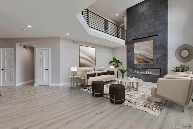 living room featuring light hardwood / wood-style flooring and a tile fireplace