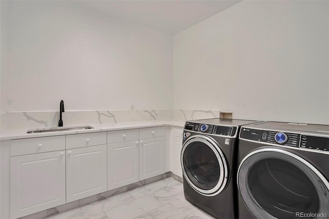 laundry area featuring cabinets, sink, and washer and clothes dryer