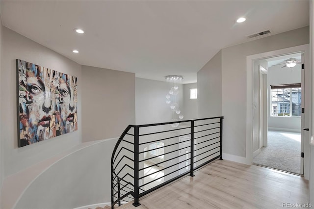 stairway featuring a notable chandelier and hardwood / wood-style flooring