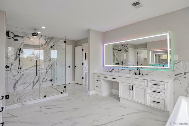 bathroom featuring a shower with door and vanity