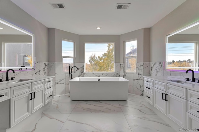 bathroom featuring tile walls, vanity, and a tub to relax in