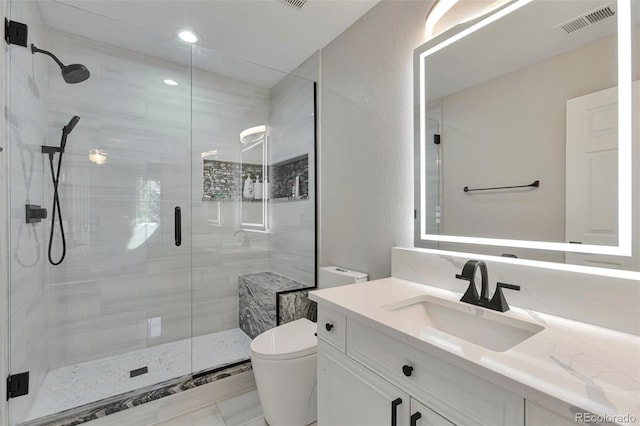 bathroom featuring vanity, toilet, and an enclosed shower