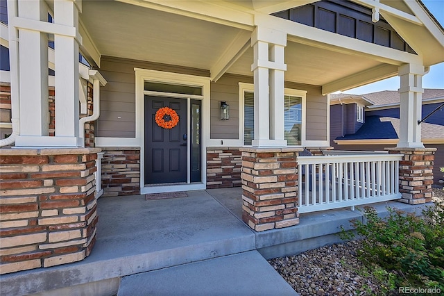 view of exterior entry featuring covered porch