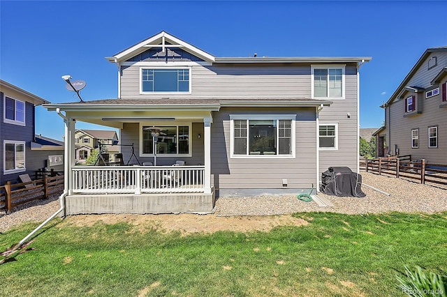 back of property with a porch and a yard