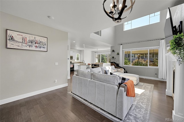 living room featuring an inviting chandelier and dark wood-type flooring