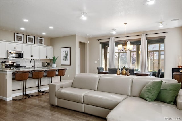 living room with dark hardwood / wood-style flooring and a chandelier