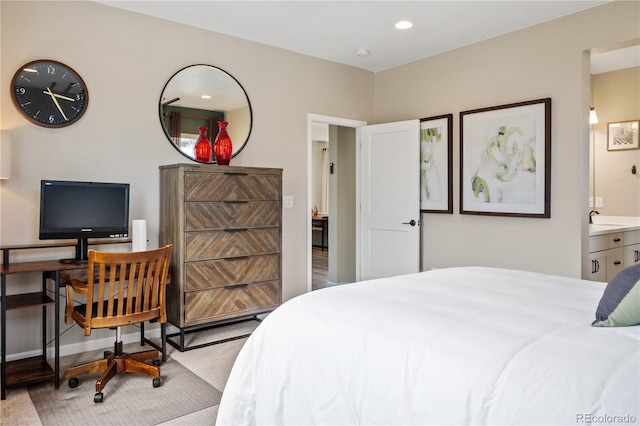 carpeted bedroom with ensuite bathroom and sink