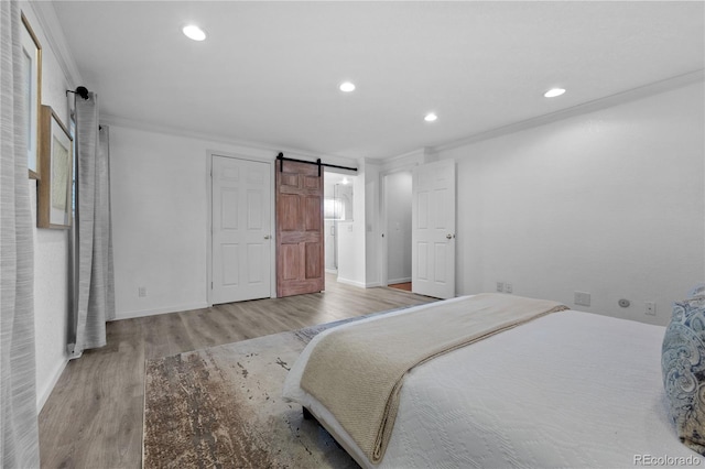 6243 S Elati St, Littleton, CO 80120 - bedroom featuring ornamental molding, wood finished floors, recessed lighting, and a barn door