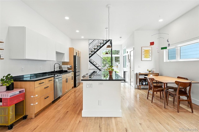 4129 Zenobia St, Denver, CO 80212 - kitchen featuring freestanding refrigerator, dishwasher, light wood finished floors, white cabinetry, and a kitchen island