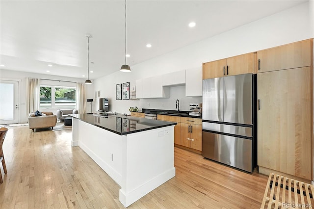 4129 Zenobia St, Denver, CO 80212 - kitchen with freestanding refrigerator, dark countertops, a kitchen island, light wood-style flooring, and open floor plan