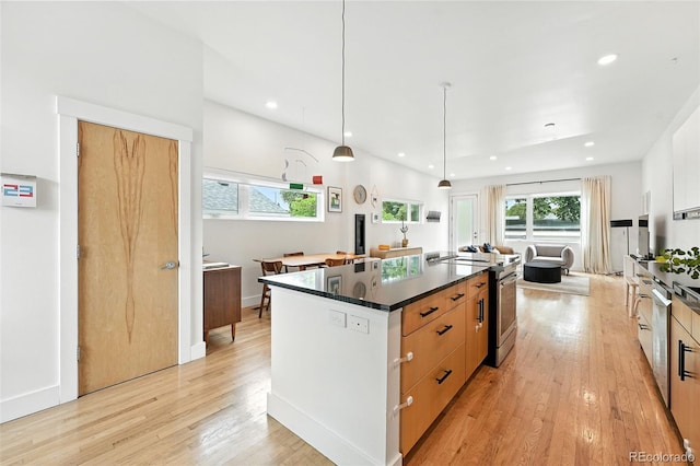 4129 Zenobia St, Denver, CO 80212 - kitchen featuring dark countertops, light wood-style floors, a large island with sink, modern cabinets, and recessed lighting