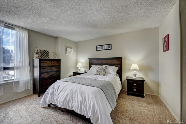 bedroom featuring light carpet and a textured ceiling