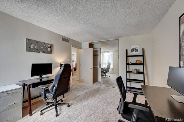 carpeted home office with a textured ceiling