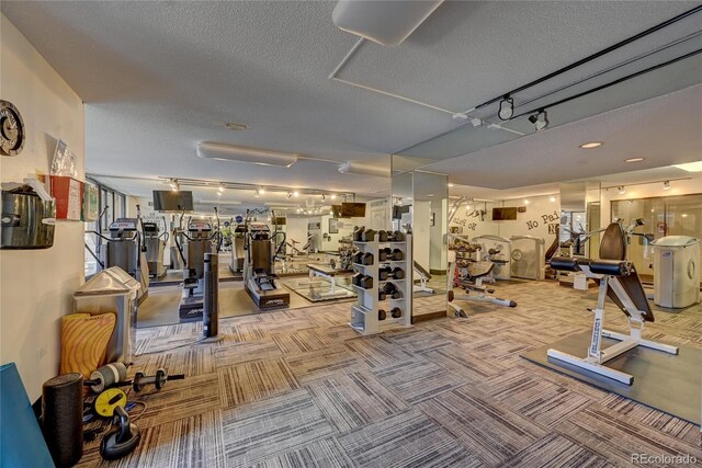 gym with light colored carpet and a textured ceiling