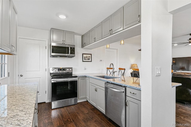 5385 W 51st Ave, Denver, CO 80212 - kitchen featuring appliances with stainless steel finishes, a sink, gray cabinets, dark wood-style floors, and ceiling fan