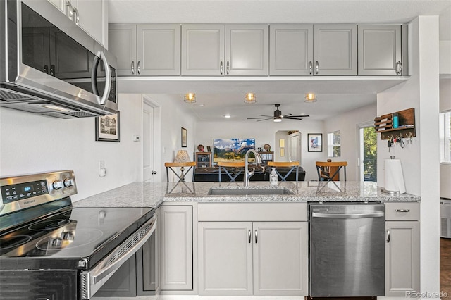 5385 W 51st Ave, Denver, CO 80212 - kitchen featuring appliances with stainless steel finishes, a sink, ceiling fan, and light stone countertops