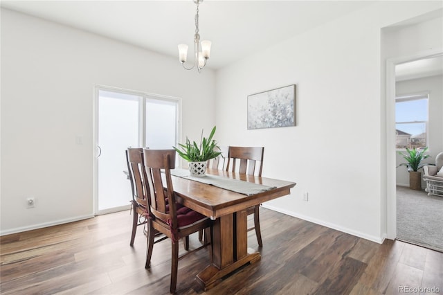dining area featuring an inviting chandelier, wood finished floors, and baseboards
