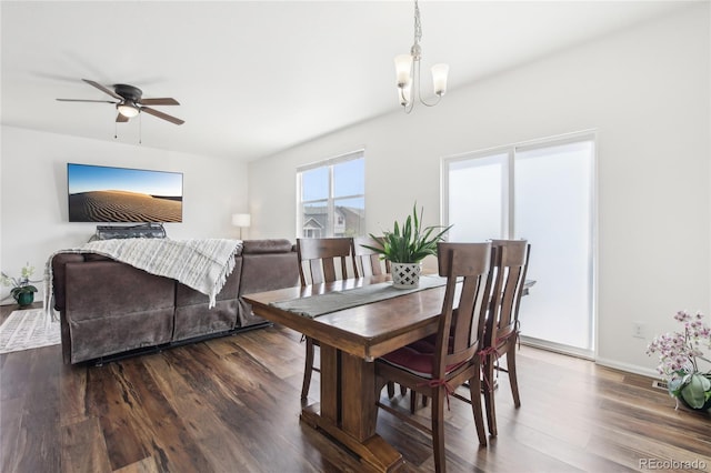 dining area featuring baseboards, ceiling fan with notable chandelier, and dark wood-type flooring