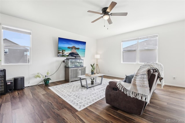 living area featuring baseboards, a ceiling fan, and wood finished floors