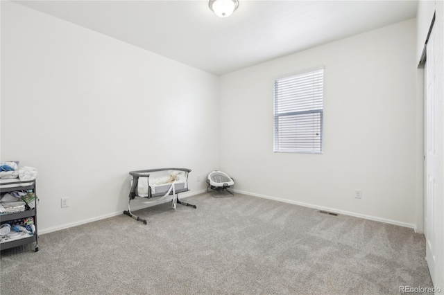 carpeted empty room featuring visible vents and baseboards