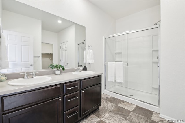 full bath featuring a shower stall, double vanity, and a sink