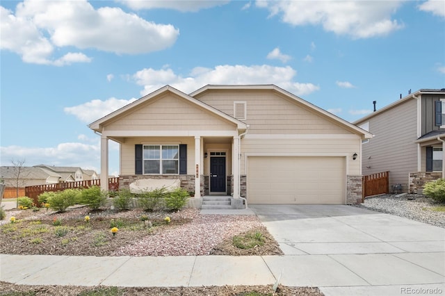 craftsman inspired home featuring a porch, fence, an attached garage, stone siding, and concrete driveway