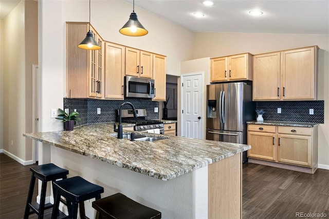 kitchen featuring appliances with stainless steel finishes, light brown cabinetry, kitchen peninsula, and light stone countertops