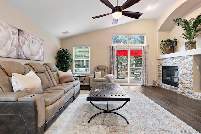 living room with a fireplace, wood-type flooring, ceiling fan, and vaulted ceiling