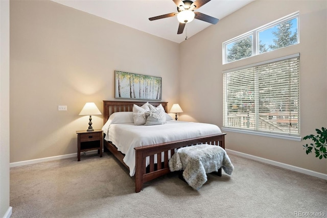 bedroom featuring multiple windows, light colored carpet, and ceiling fan