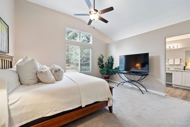 bedroom featuring high vaulted ceiling, sink, light colored carpet, ceiling fan, and ensuite bath