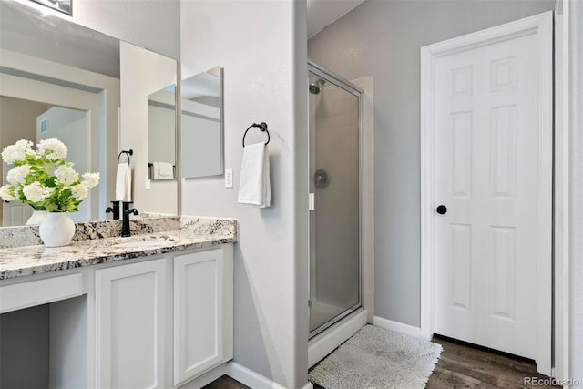 bathroom featuring hardwood / wood-style flooring, vanity, and an enclosed shower