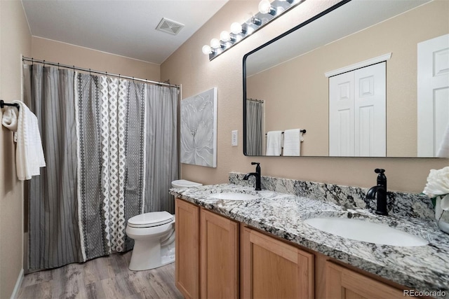 bathroom with a shower with curtain, vanity, toilet, and wood-type flooring