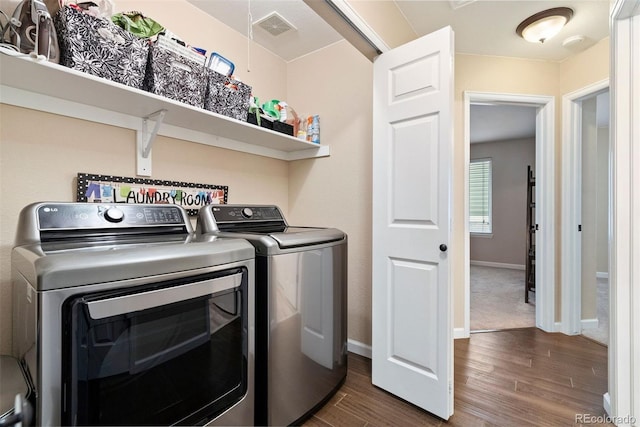 clothes washing area featuring dark hardwood / wood-style flooring and washing machine and dryer