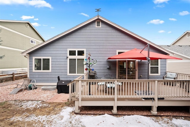 snow covered house featuring a deck