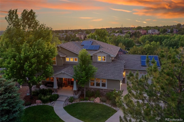 24965 E Roxbury Pl, Aurora, CO 80016 - view of front of property with solar panels, a front yard, stone siding, and roof with shingles