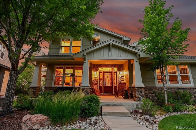 24965 E Roxbury Pl, Aurora, CO 80016 - doorway to property featuring a porch, stone siding, and board and batten siding