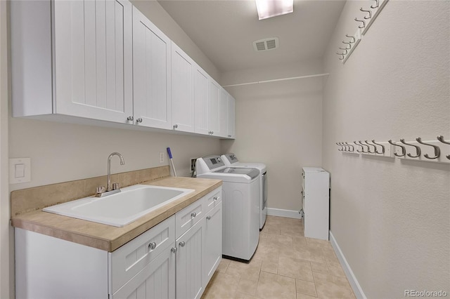 24965 E Roxbury Pl, Aurora, CO 80016 - laundry area featuring cabinet space, washer and dryer, and light tile patterned floors