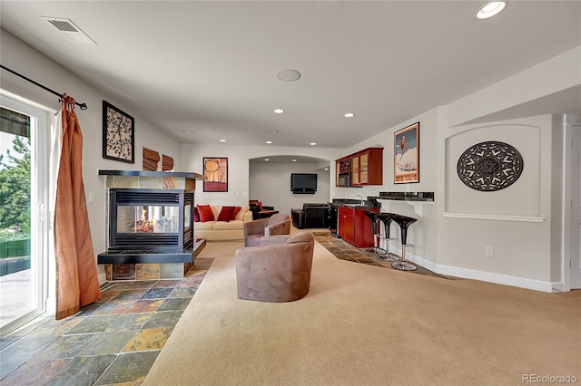 24965 E Roxbury Pl, Aurora, CO 80016 - living area featuring recessed lighting, bar, stone tile flooring, and a tiled fireplace